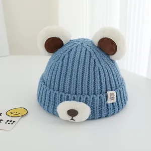 Detailed knit texture of blue winter baby hat with cute bear ears and plush accents