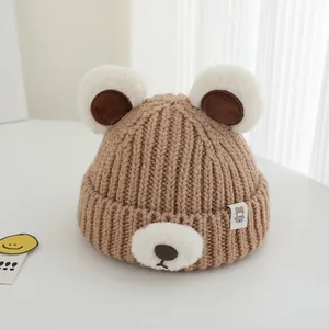 Close-up of brown knit baby hat featuring plush bear ears and soft textures for winter