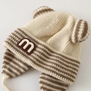 Detail of baby striped knit hat showing the soft earflap texture and cute 3D bear ears
