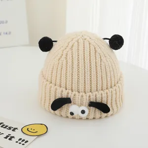 Texture détaillée d'un bonnet d'hiver en tricot beige pour enfant avec design mouton