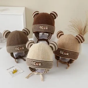 Detailed view of striped baby bear ear hats in brown, beige, and cream knitted fabric