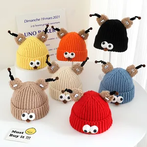 Detailed view of colorful knitted monster hats with large eyes and spiral antennae