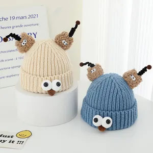 Detail of knitted monster hats showing thick wool texture and cartoon eyes for kids