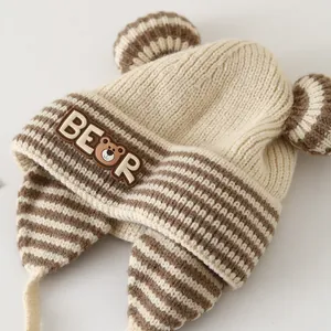 Close-up of baby knit winter hat with bear ears, brown stripes, and soft fleece lining