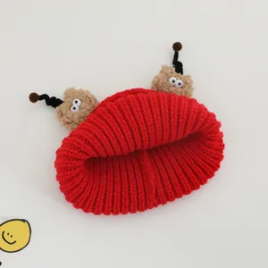 Winter knitted red baby beanie with funny large eyes and cute cartoon antennas