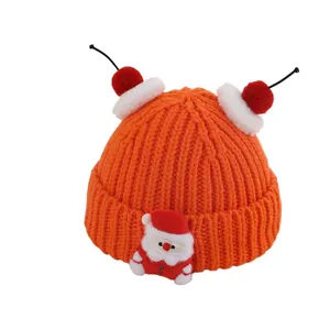Cozy orange knit Christmas hat for kids featuring a cute Santa Claus plush ornament