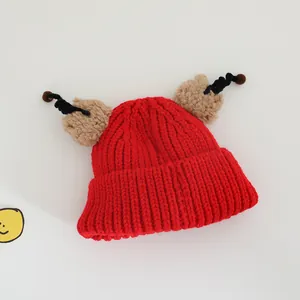 Detail of red knit kids hat with cute cartoon tentacles and plush round ears