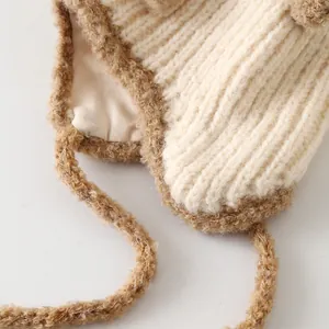 Détail du bonnet en maille avec bordure en polaire sherpa et attaches contrastées