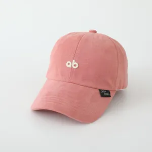 Detail van roze katoenen baseballcap met wit AB-borduurwerk en zijdelings merklabel