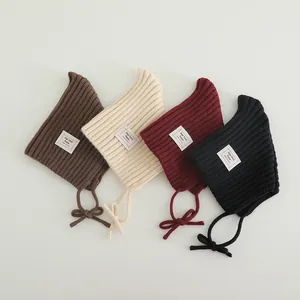 Cute pointed knit beanie for babies in brown cream red and black with earflaps and chin straps