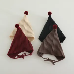 Detail of knitted baby elf hats with pom-poms and windproof ties in four colors