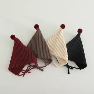 Detail of soft ribbed knit baby elf hats with pom-poms and chin straps in four colors