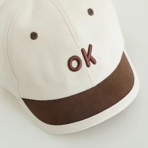 Süße Baby-Baseballkappe mit OK-Stickerei und Kontrastschirm in Creme und Braun