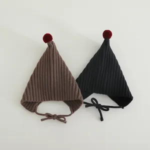 Detailed texture of knit baby elf hats with red pom-poms and matching chin straps