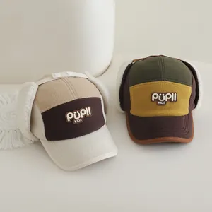 Detail of warm winter pilot hats for kids with plush lining and PUPIL KIDS embroidery