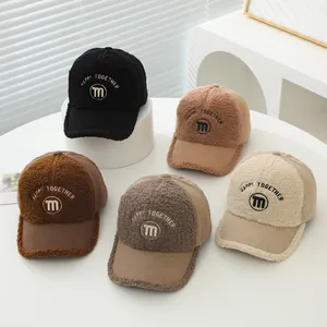 Detailed view of kids corduroy baseball caps in five earthy colors with letter M embroidery