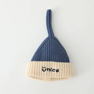 Winter knit baby beanie with contrast colors, pointed top, and embroidered Unice text