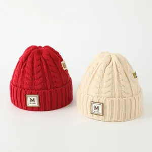 Bonnet tricoté d'hiver pour enfants avec écusson lettre M en rouge et beige