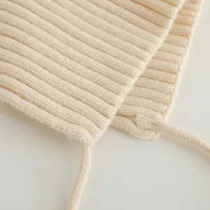 Macro view of cream knit baby hat showing premium ribbed texture and knit straps