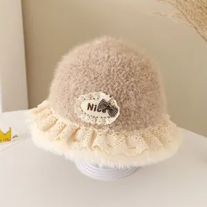 Close-up of children's fleece bucket hat featuring lace trim and checkered bow detail