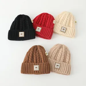 Cinq bonnets en tricot d'hiver assortis avec écussons lettre M en couleurs variées