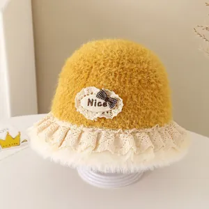 Detailed macro view of yellow plush baby bucket hat with lace trim and Nice bow patch