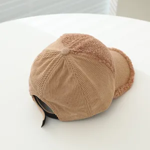 Detailed texture of corduroy and lamb wool patchwork on child baseball cap with strap