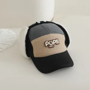 Detail of warm winter trapper hat for kids featuring plush earflaps and PUPII embroidery