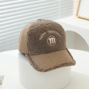 Close-up of brown corduroy and faux shearling baseball cap with M letter embroidery