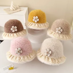 Detail of plush baby bucket hats with lace trim and flower accents in five warm colors