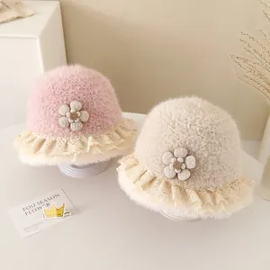 Detail of plush baby bucket hats with delicate lace trim and floral button accents