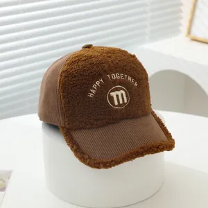 Close-up of brown corduroy and fleece baseball cap featuring M letter embroidery
