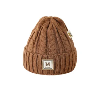 Bonnet en tricot torsadé pour enfants avec écusson lettre M stylé en marron foncé