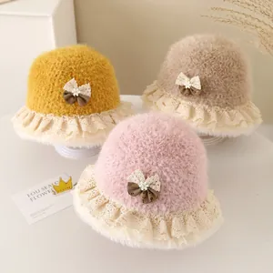 Detail view of plush baby bucket hats in yellow pink and beige with lace and bow details