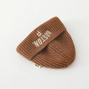 Detail of caramel brown knit beanie with Boston embroidery and ribbed texture