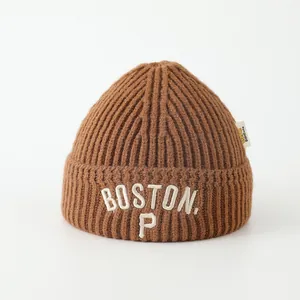 Close-up of brown knit beanie featuring white BOSTON 3D embroidery and thick rib texture