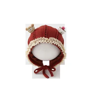 Cute knitted baby earflap hat in burgundy with lace trim and smile bear decor