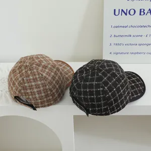 Détail de casquettes de baseball en laine à carreaux vintage marron et gris pour hiver