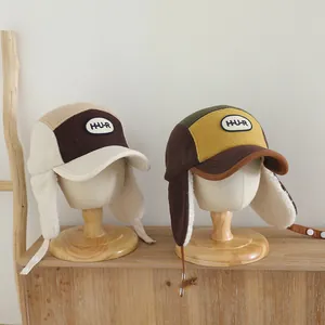 Detalle de gorros de aviador para niños bicolor con forro polar y parche de letras H-U-R