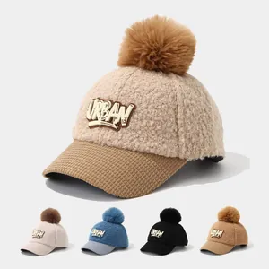 Close-up of children's lamb wool baseball cap with URBAN patch and faux fur pom-pom
