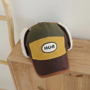 Detalle de gorro de invierno para niños con forro polar y parche de letras H-U-R