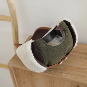 Detalle de gorra de invierno con orejeras en forro polar verde oliva y piel sintética blanca