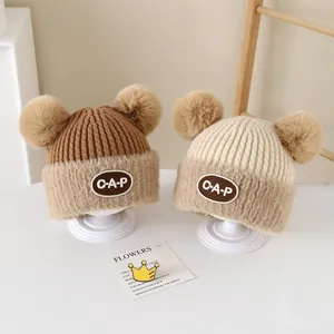 Cozy knit baby hat with double faux fur pom-poms and CAP patch in brown and beige