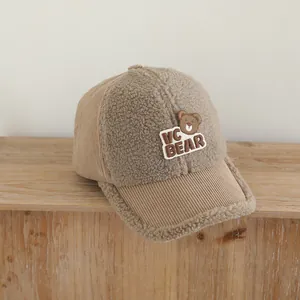 Detail einer braunen Baseballkappe aus Cord und Lammfellimitat mit Bären-Aufnäher