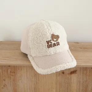Nahaufnahme der Baby-Basecap mit cremefarbenem Teddyfell und rosa Cordstoff-Texturen