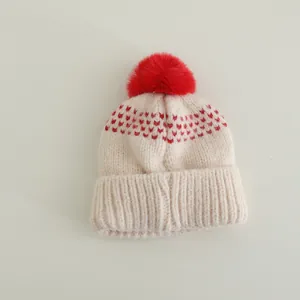 Kids chunky knit beanie with red pom-pom and heart patterns in cream white finish