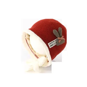 Deep red baby knit bonnet with plush white faux fur lining and checkered rabbit ears