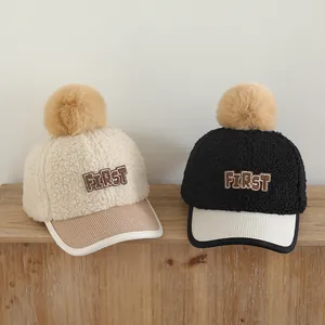 Détail de casquettes de baseball en polaire pour enfants avec pompon et broderie FIRST