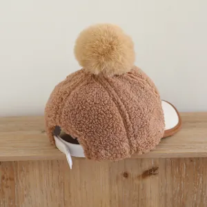 Brown sherpa baseball cap for kids with plush pompom and adjustable strap