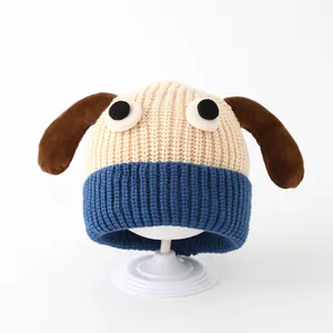Cute toddler knit beanie with plush long ears and cartoon eyes on a white stand